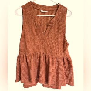 Burnt orange waffle knit summer top with ruffle bottom.